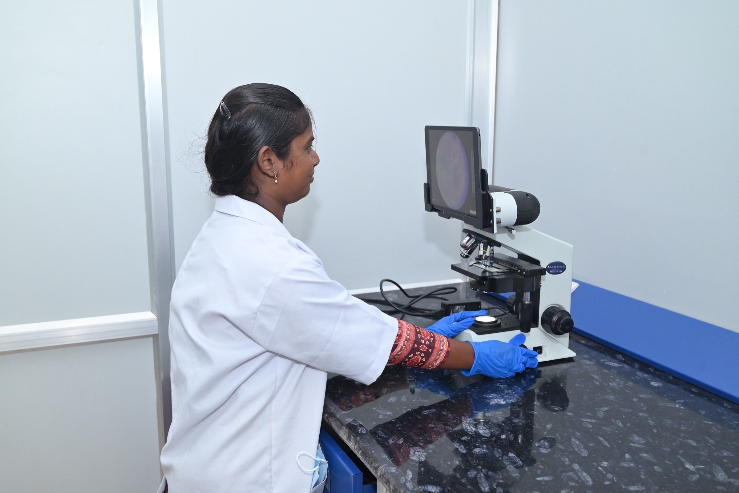 Microbiologist examining a slide on the digital microscope
